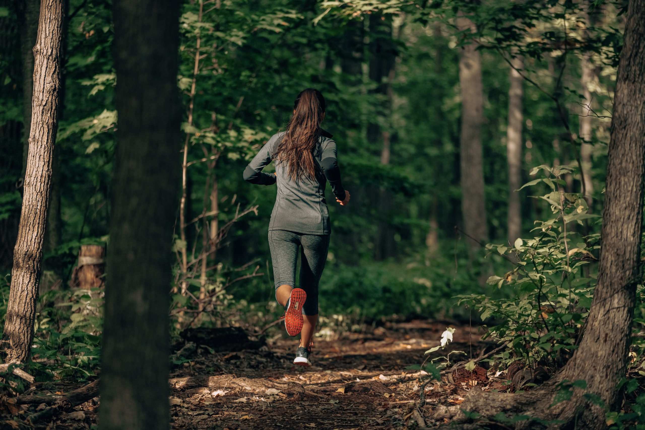 A woman runs through the woods