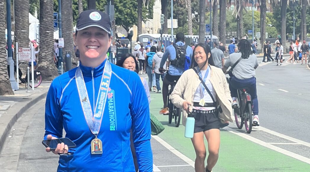 Runner Spotlight star Lucie Nestrasilova waslking down the road with her dream race San Francisco Marathon medal around her neck