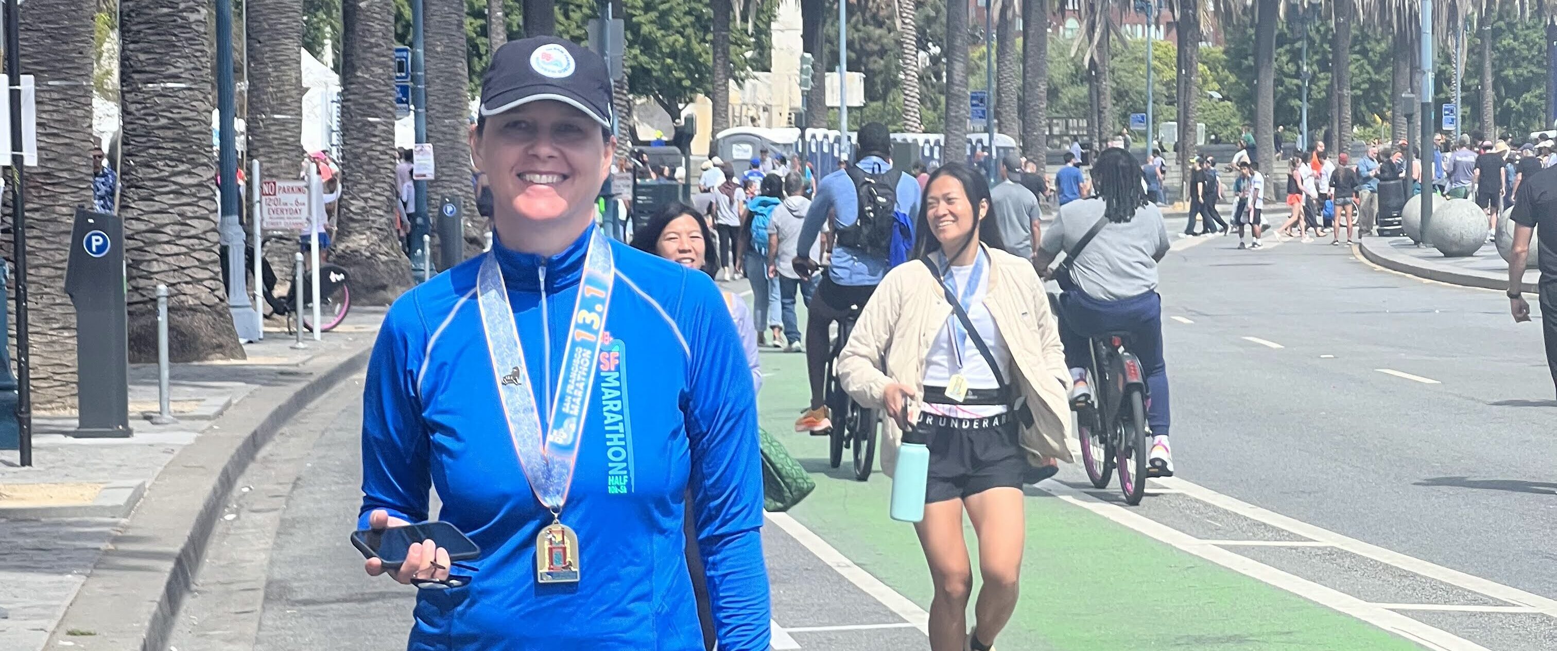 Runner Spotlight star Lucie Nestrasilova waslking down the road with her dream race San Francisco Marathon medal around her neck