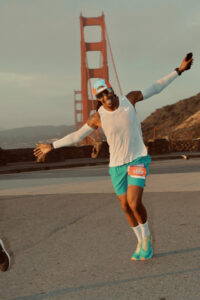 Sanyika Shakur runs in the San Francisco Marathon, with the Golden Gate Bridge in the background.