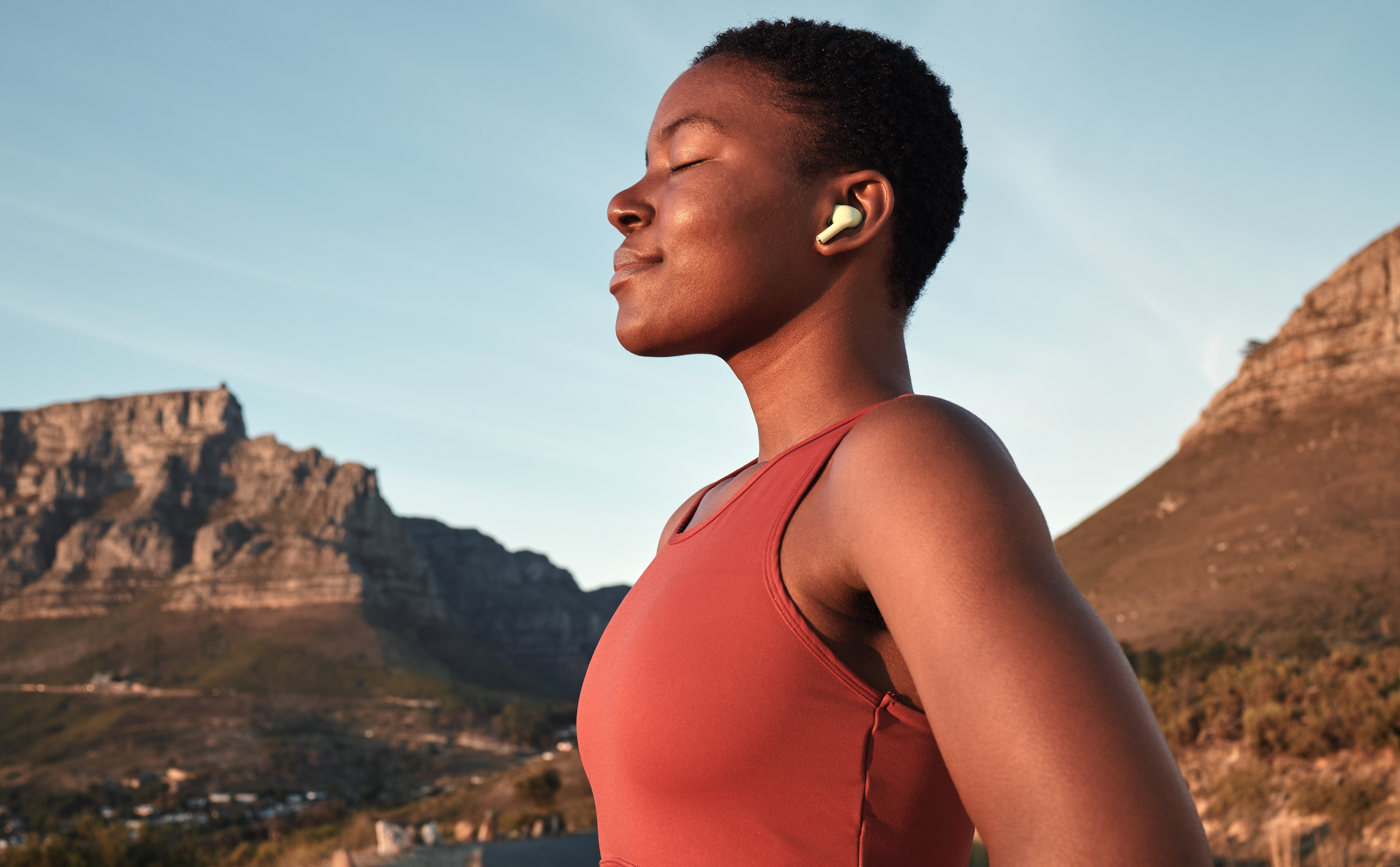 A Black woman runner with closed eyes in a desert enjoying the last sunrays, overcame the training traps and went running