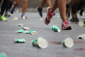 Runners run over paper cups during a major marathon