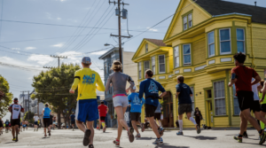 Marathoners stride through the vibrant Mission District, cheered on by local color and community energy.