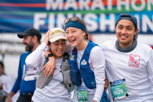 Three runners celebrate together at the finish line of the 2025 San Francisco Marathon.