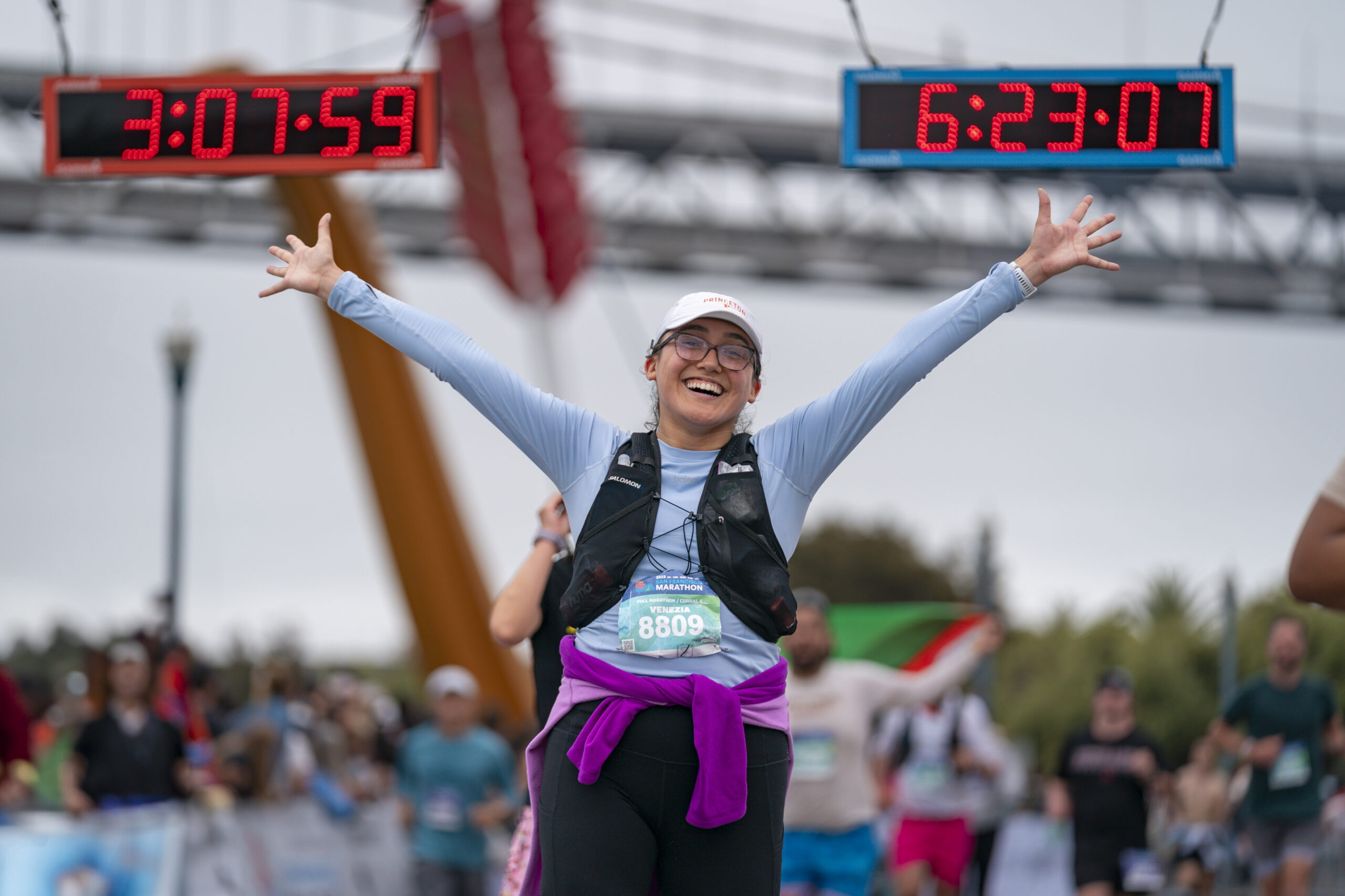 A happy runner crosses the finish line of the 2025 san francisco marathon, starting her post-race recovery journey