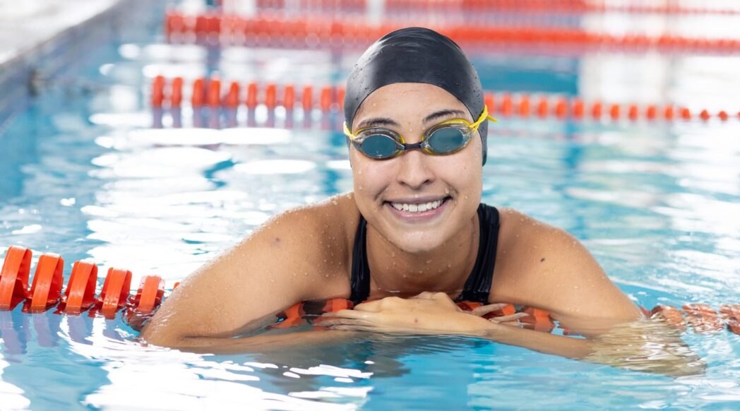 A woman partway through her triathlon smiles at the camera