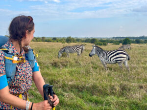 The author stands next to a herd of wild zebra in the Kenyan savanna