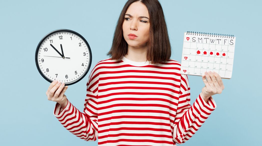 A woman looks between a clock and a calendar with her period marked out, perhaps considering running.