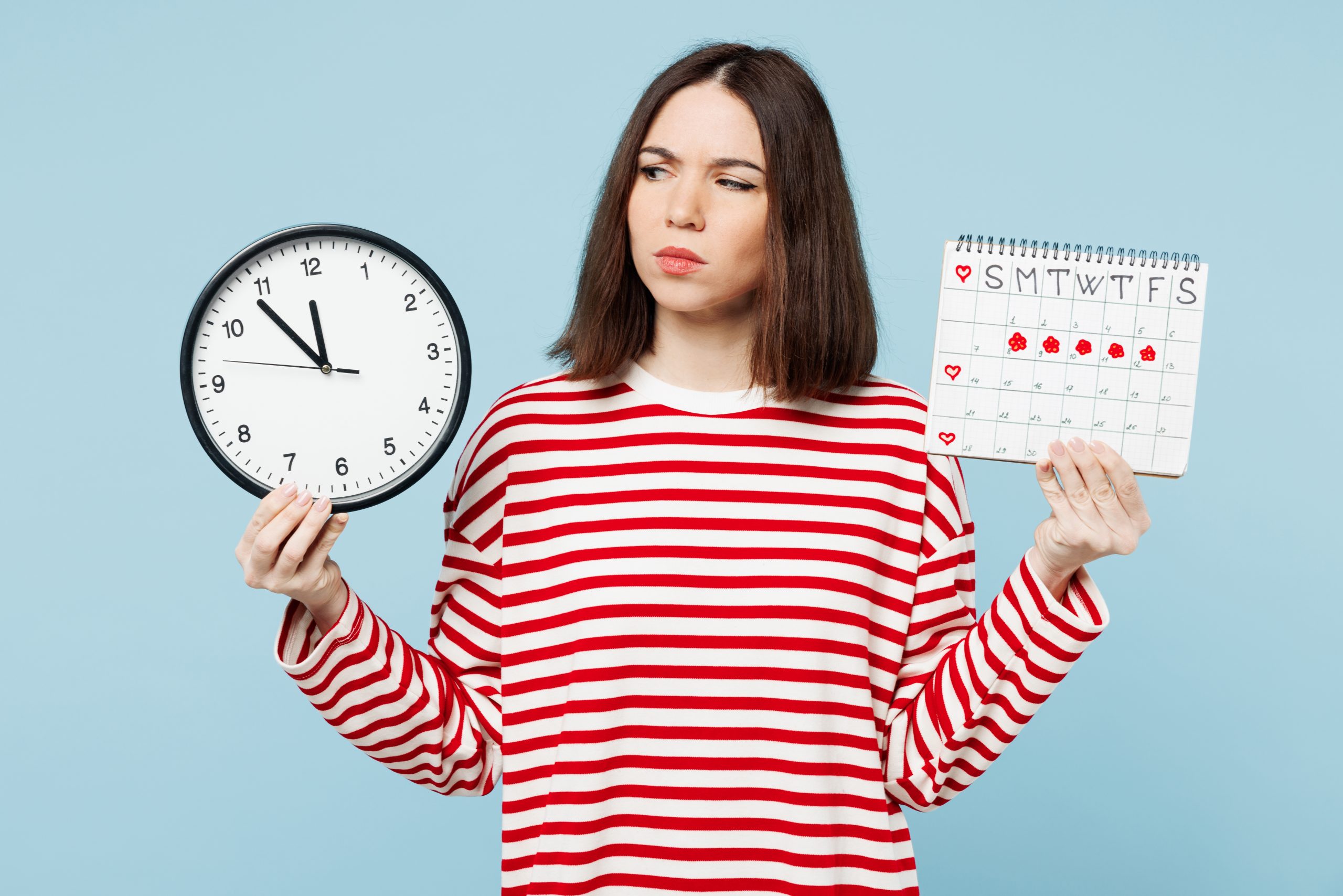 A woman looks between a clock and a calendar with her period marked out, perhaps considering running.