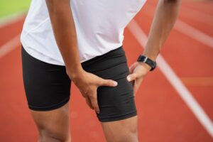 A runner hold his chafing thigh