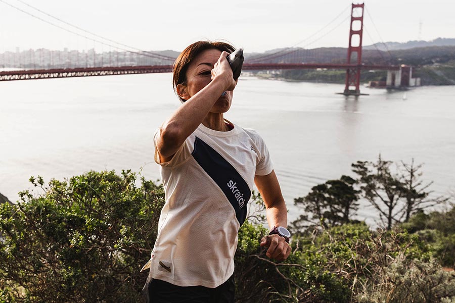 Woman hydrating during a run with the Golden Gate bridge in the background