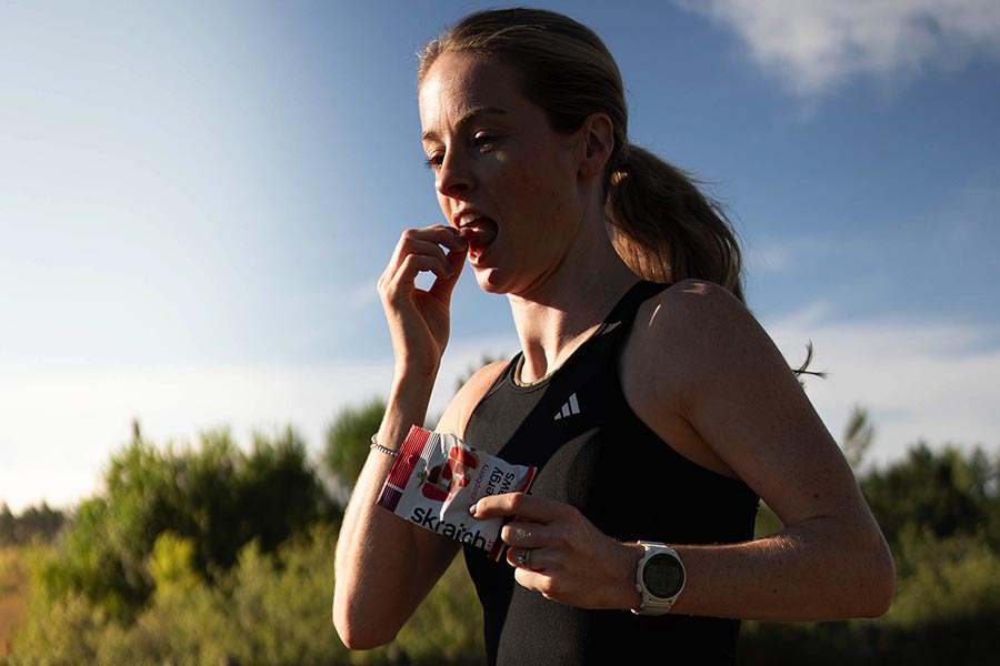 Woman running and snacking on Skratch Labs energy chews