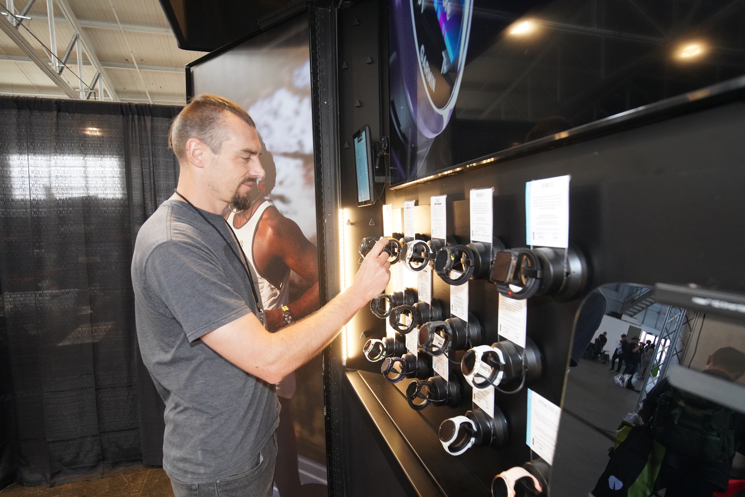 A runner at the SFM Expo is looking at a stand with watches, the Garmin Forerunner 970 included