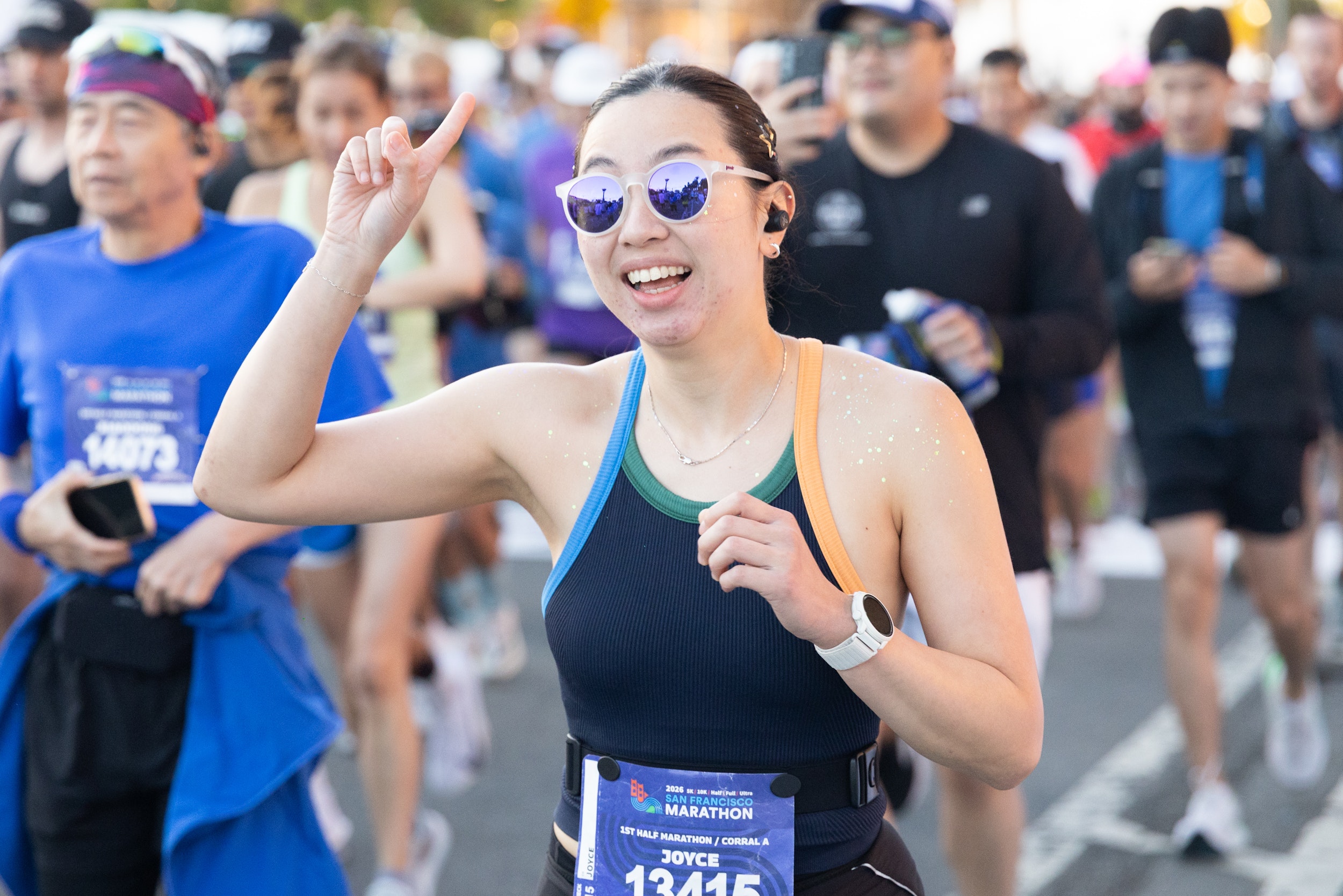 A runner points at the sky at the start line, using runner slang to tell others what's up