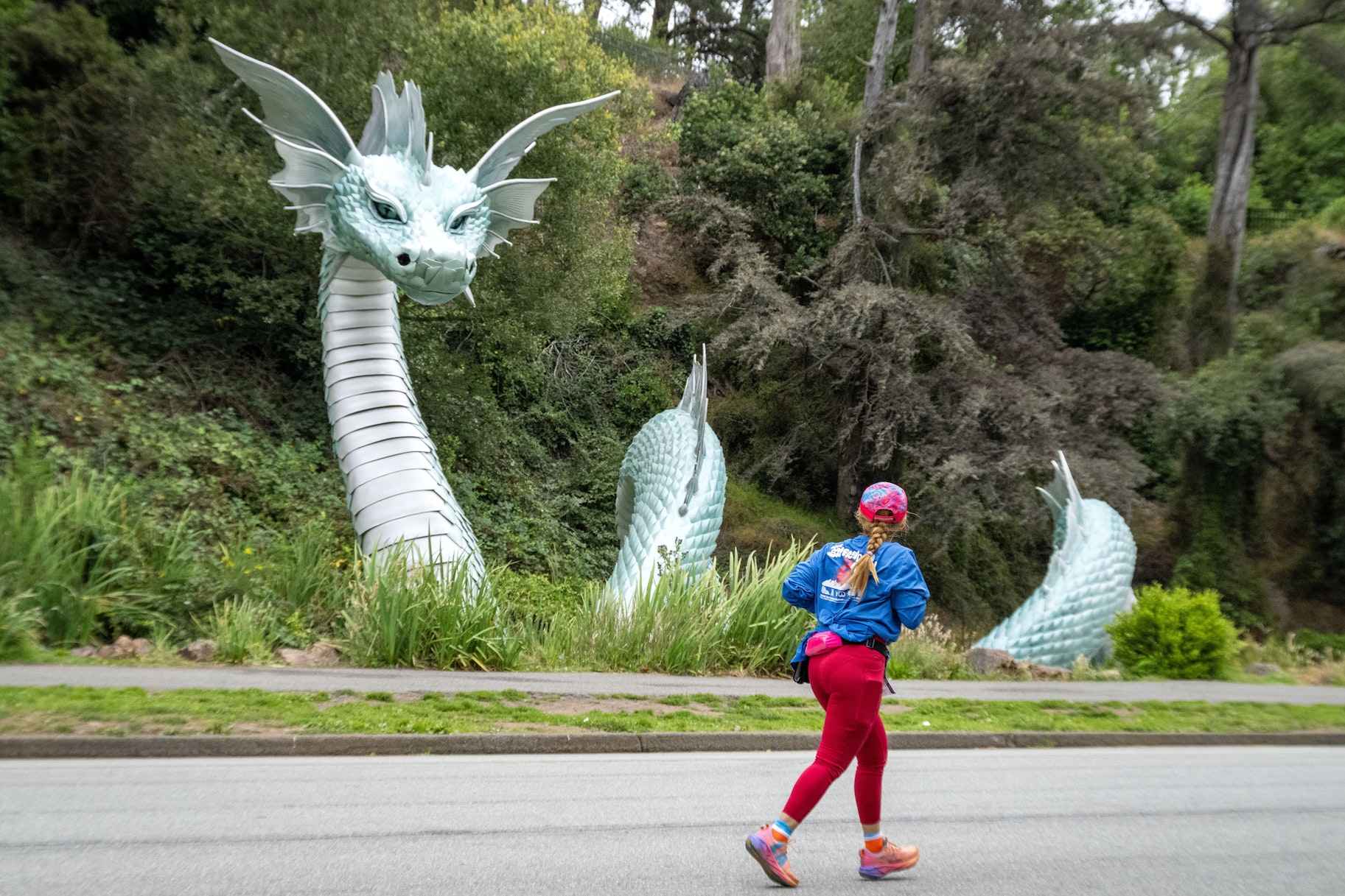 A runner runs in Golden Gate Park in front of the Naga statue